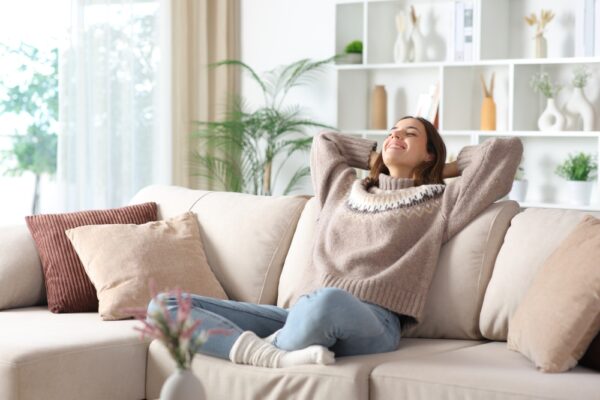 Femeie relaxându-se pe canapea într-un living luminos